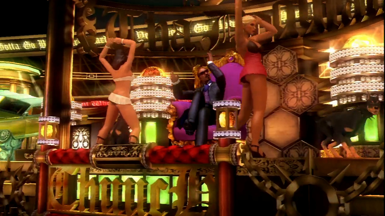 Snoop Dogg sitting atop his throne with two female dancers alongside him.